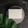 White bar of soap on a black marble surface with a green leaf - Zoom Thumbnail Media 1