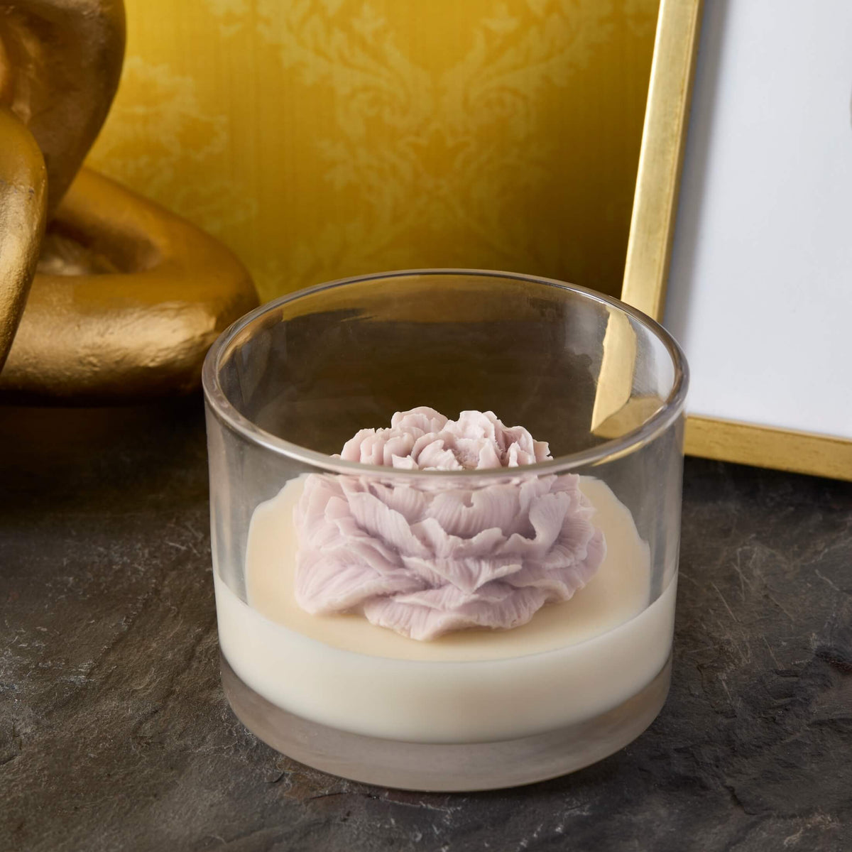 white wickless candle with purple flower embed